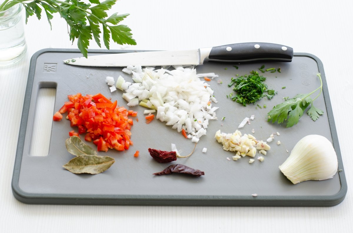 Picando las verduras para hacer los chipirones en su tinta