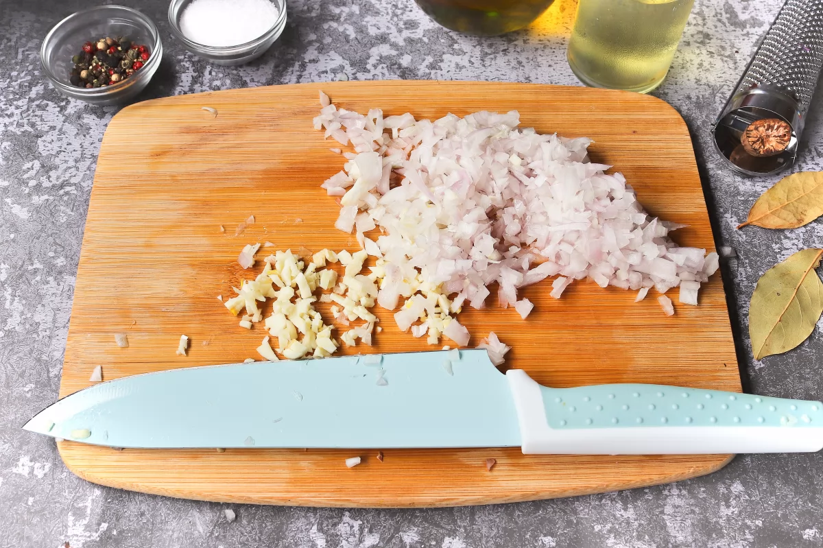 Picar cebolla y ajo carne de ternera con tomate