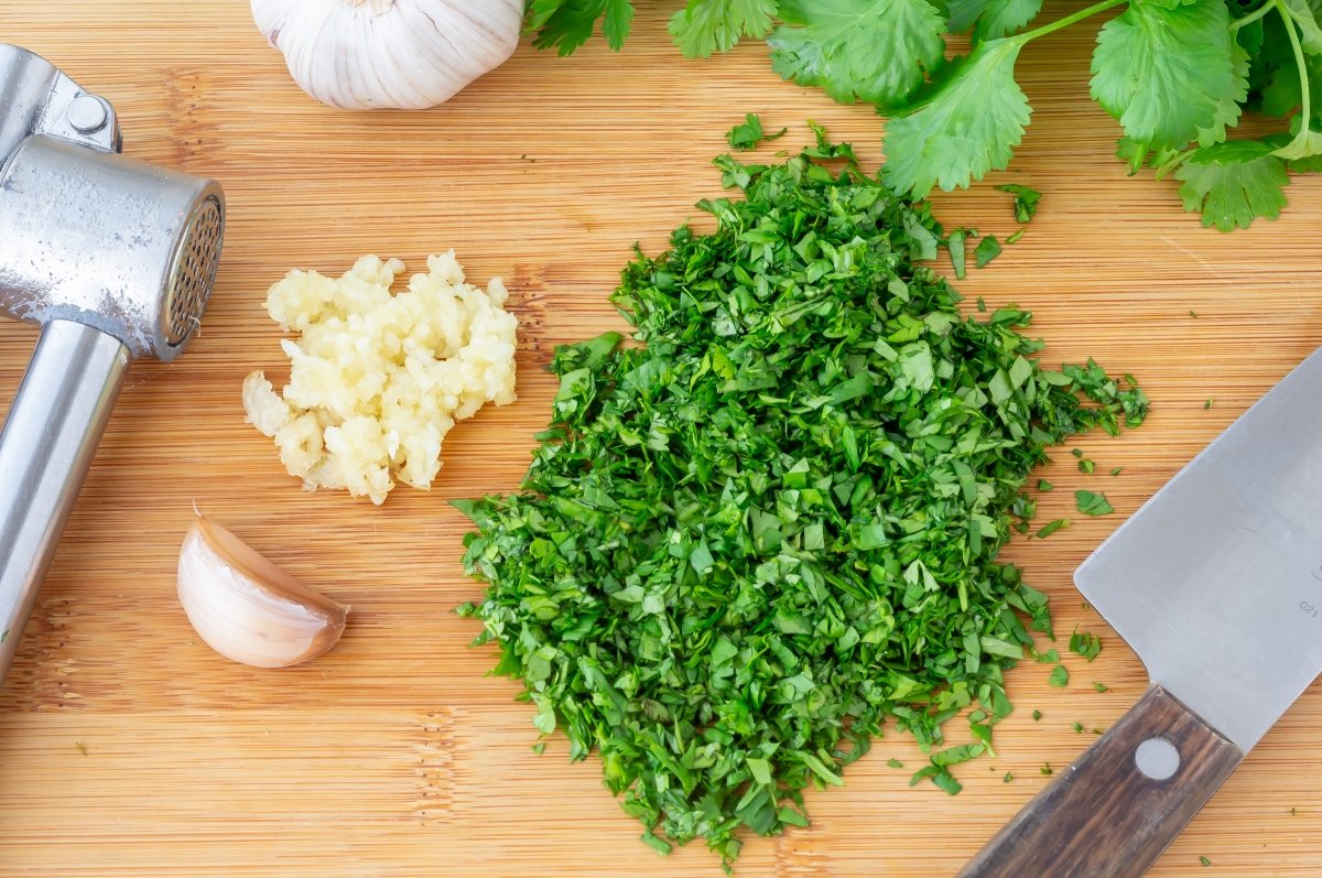 Picar el ajo y el cilantro para la salsa ají