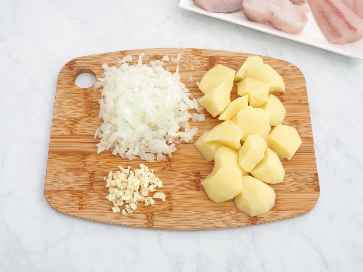 Picar el ajo y la cebolla y chascar la patata