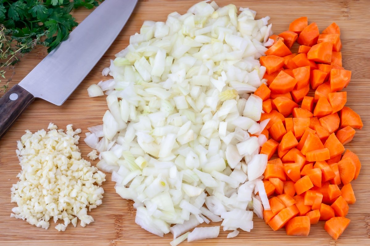 Picar las verduras para el sofrito de la carne asada