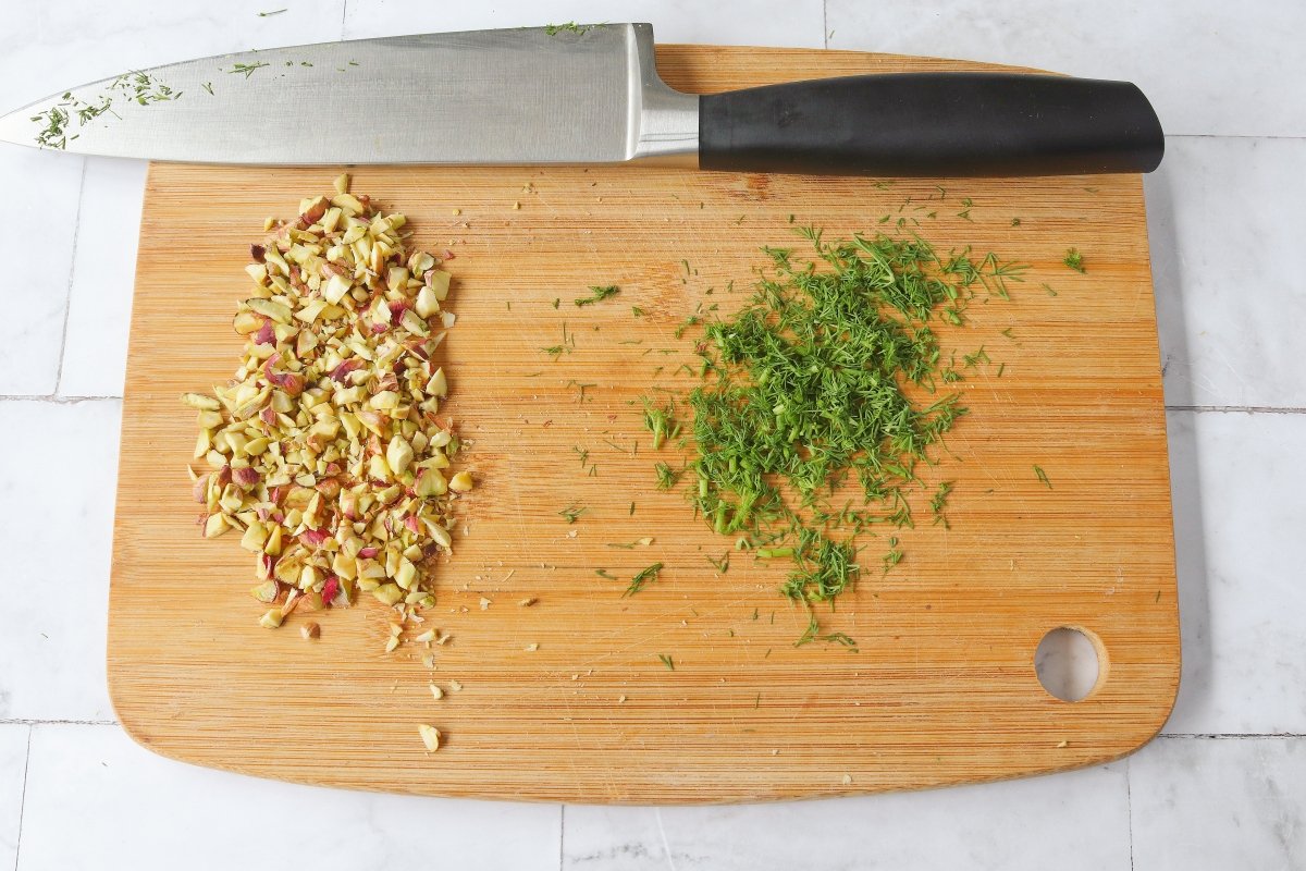 Picar los pistachos y el eneldo para la ensalada de ahumados