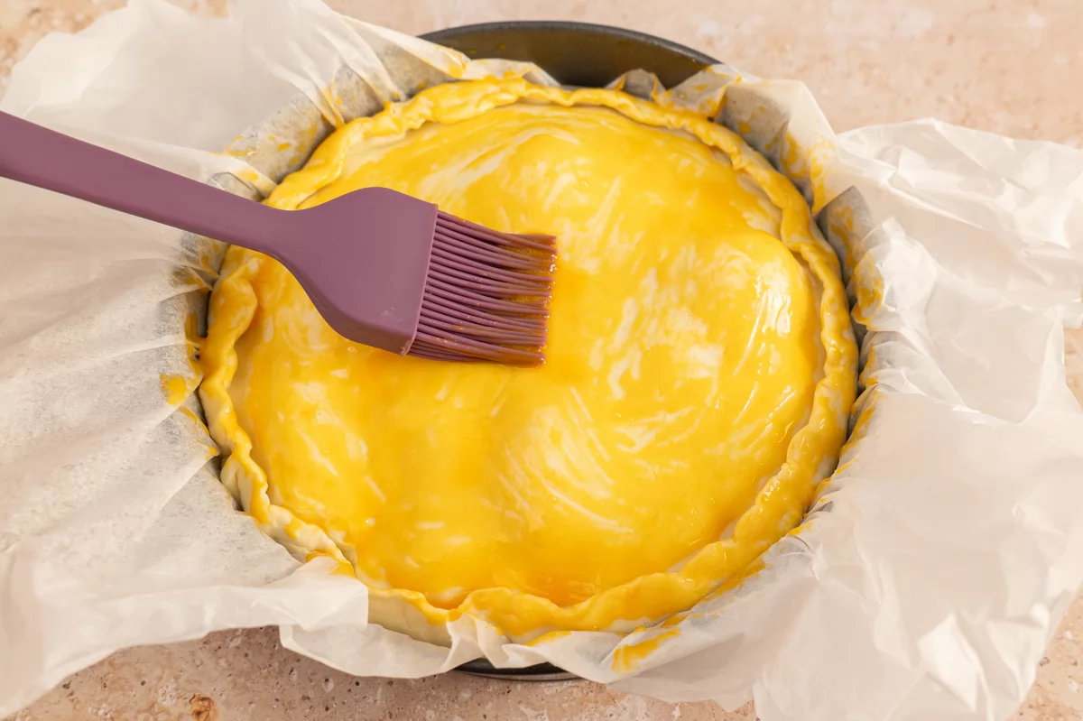 Picelar la superfice de la masa brisa con yema batida para la torta pascualina