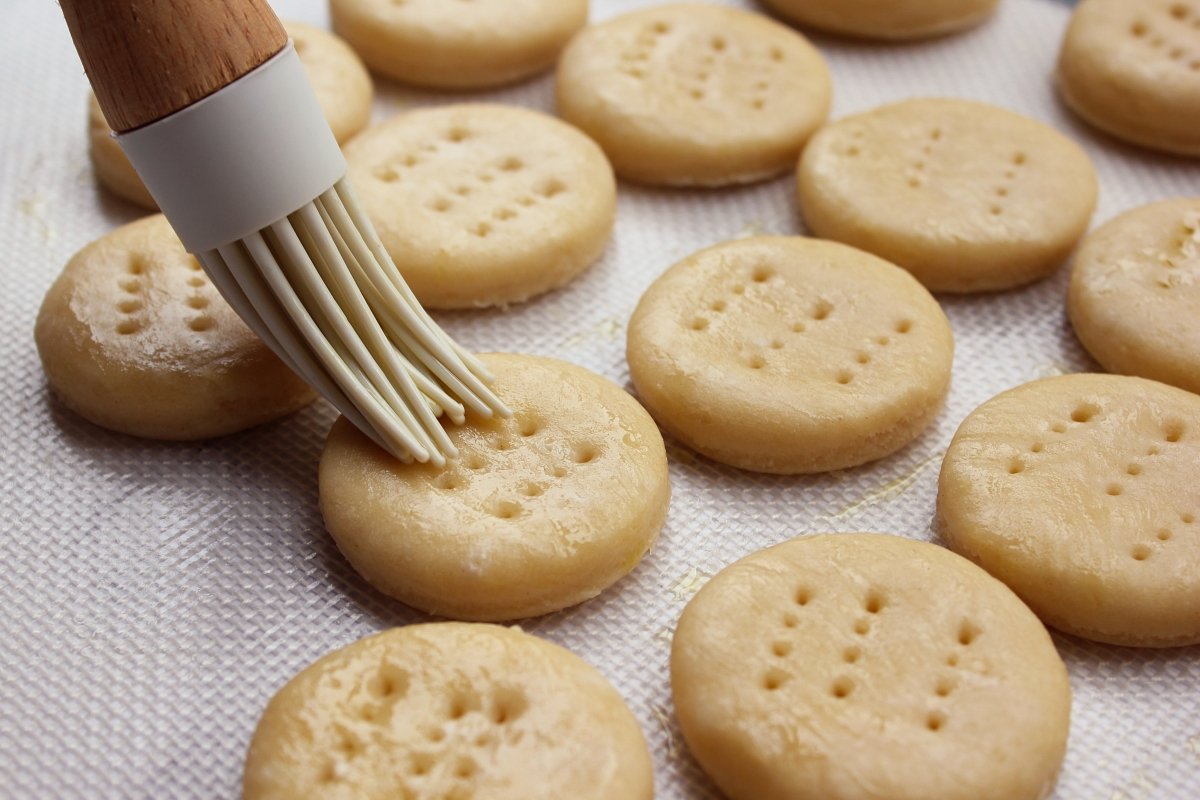 Pincelado de los bizcochitos de grasa con mantequilla