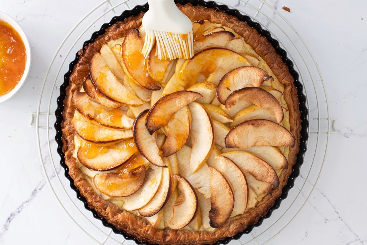 Pincelamos con mermelada la tarta de manzana con crema pastelera