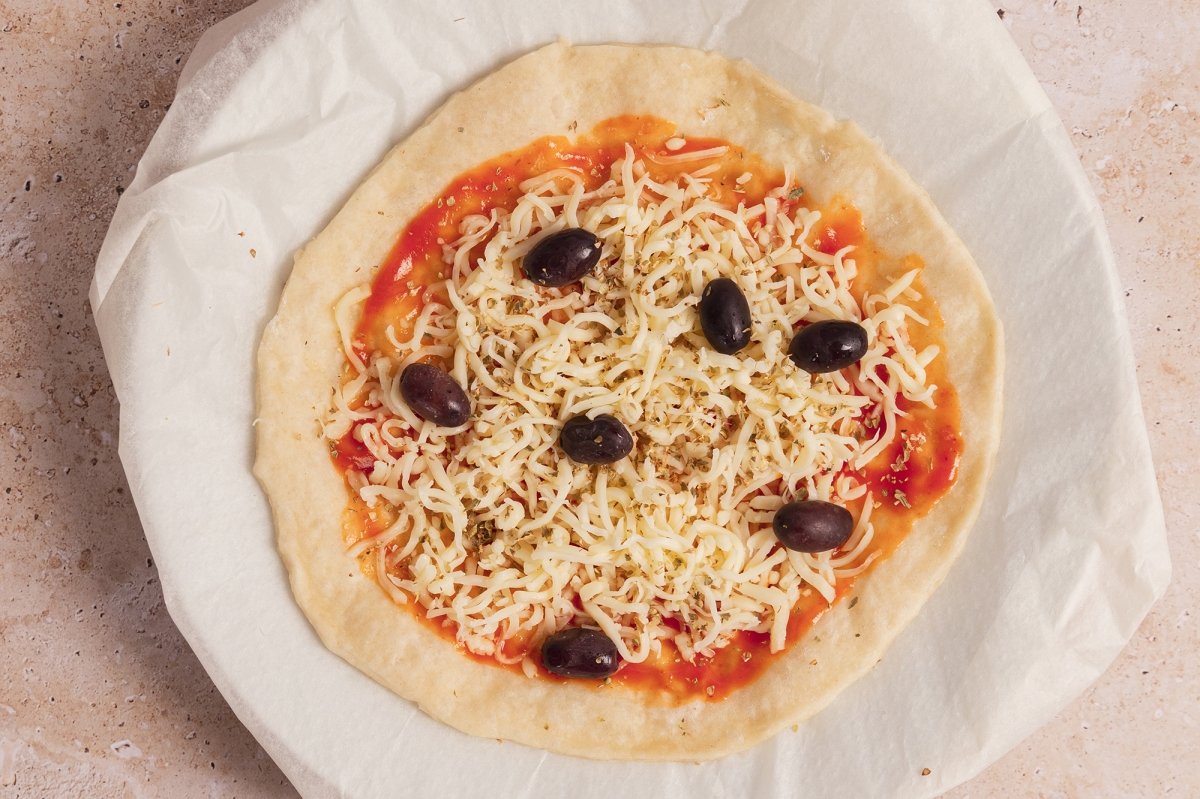 Pizza con tomate, queso, orégano y aceitunas