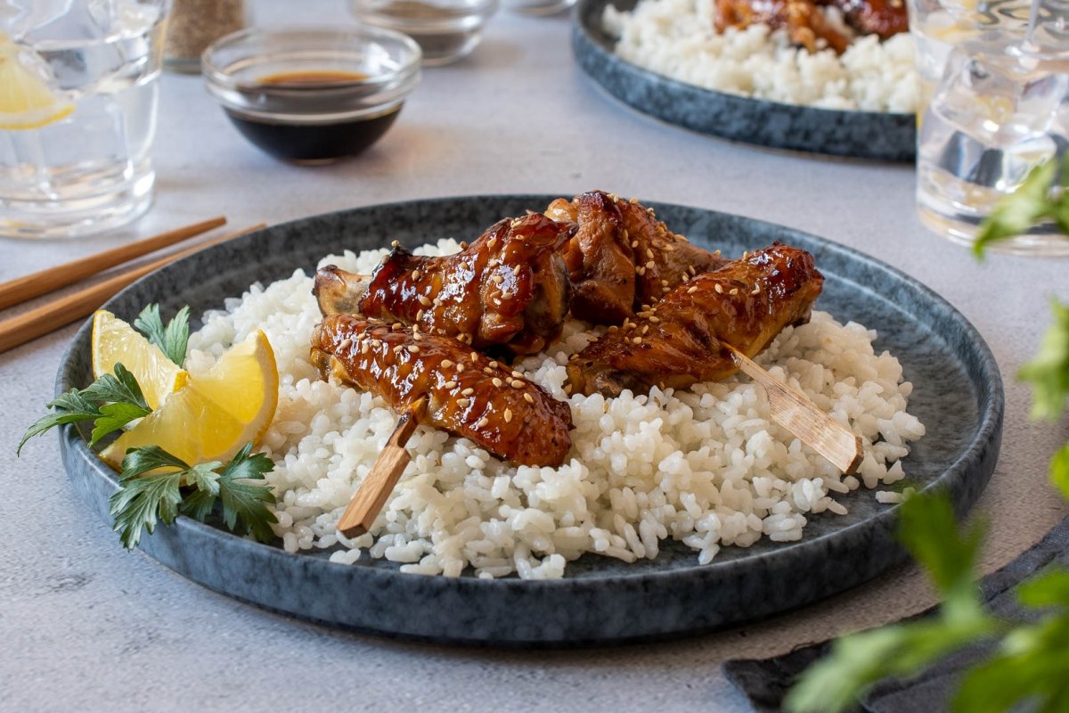 Plato de alitas de pollo en salsa teriyaki con guarnición de arroz