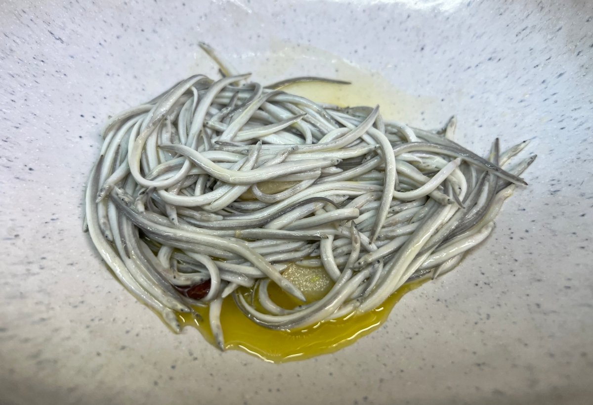 Plato de angulas servidas con sencillez en aceite de oliva