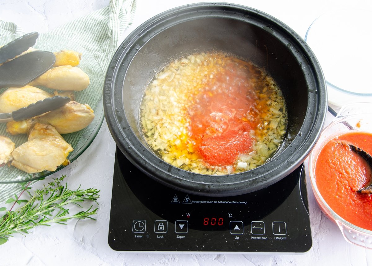 Pochando la cebolla para hacer pollo con tomate