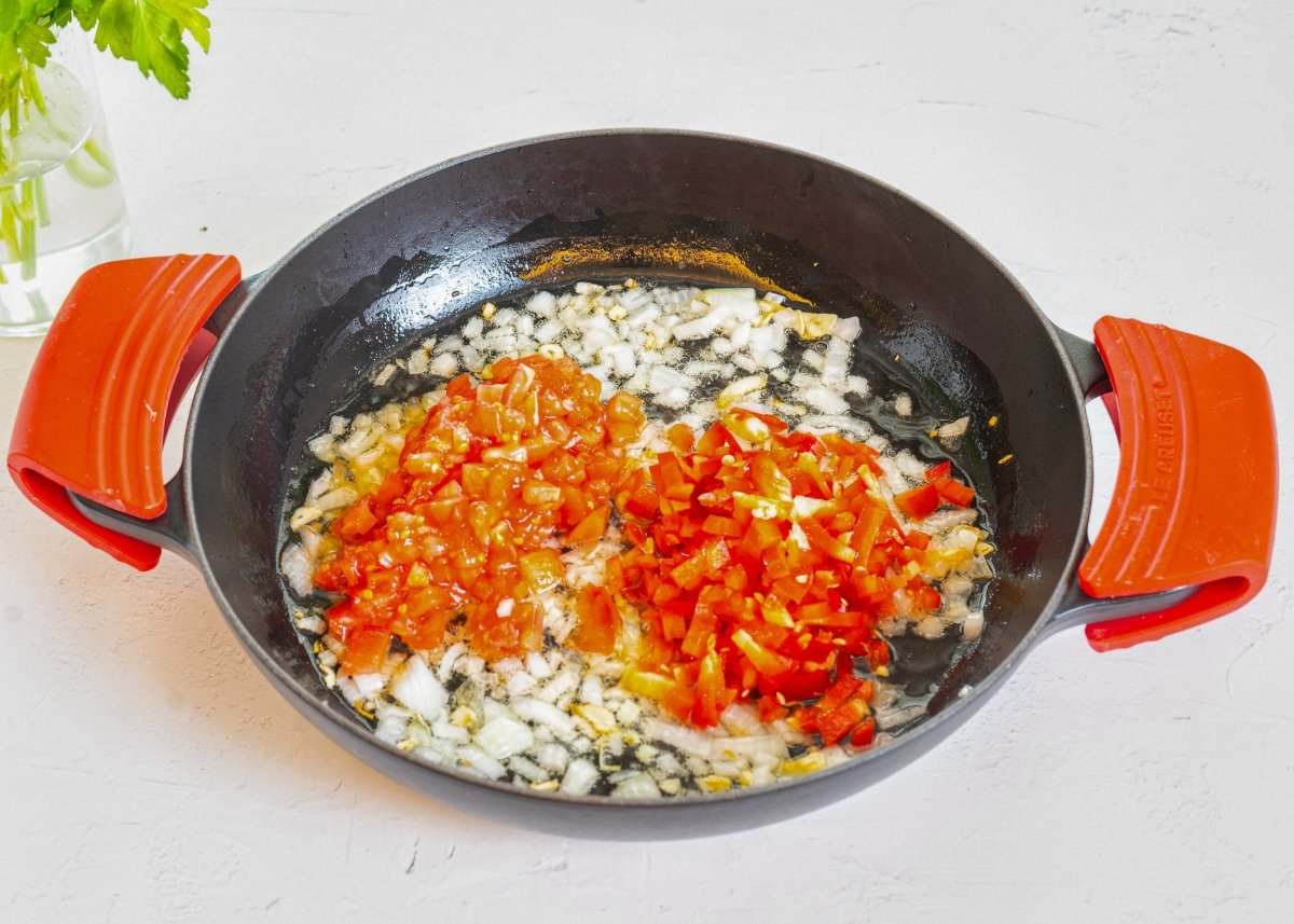 Pochando las verduras para hacer fideos con almejas