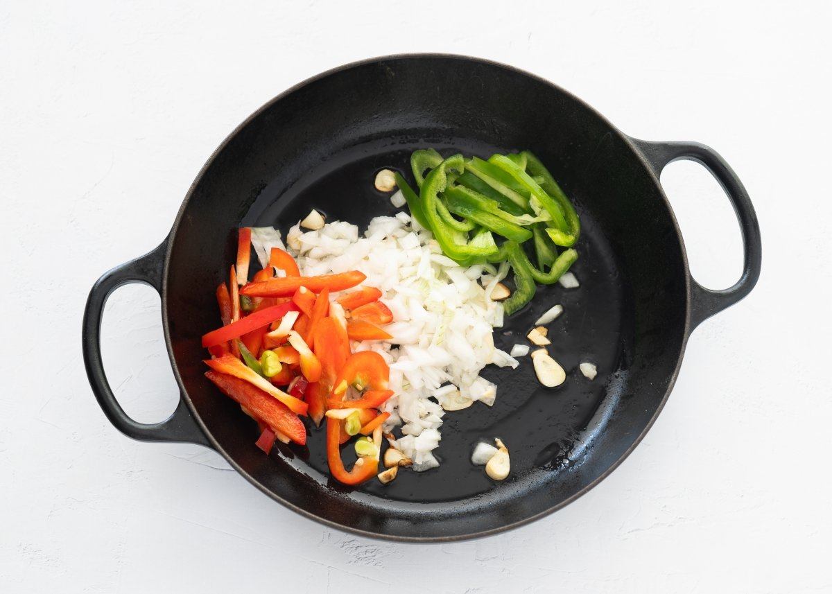 Pochando verduras para hacer bacalao con tomate y pimientos