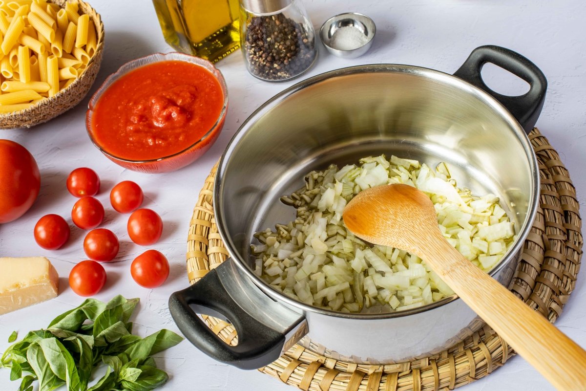 Pochar cebolla y ajos para hacer la salsa de los macarrones a la napolitana