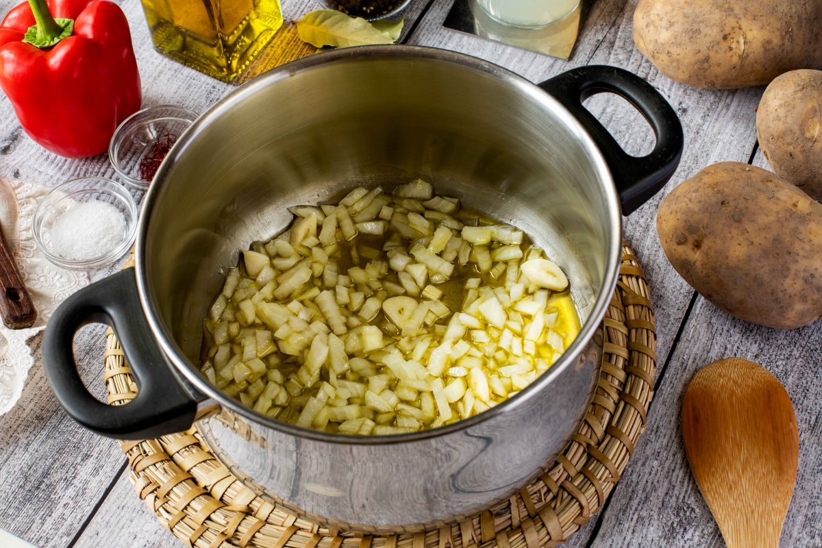 Pochar la cebolla y el ajo para hacer el guiso de patatas con chipirones