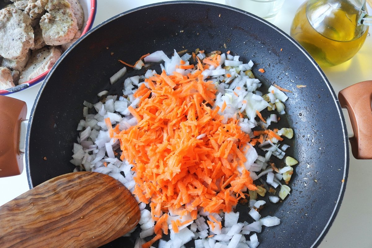 Pochar la cebolla y la zanahoria para los solomillos de cerdo en salsa tradicional