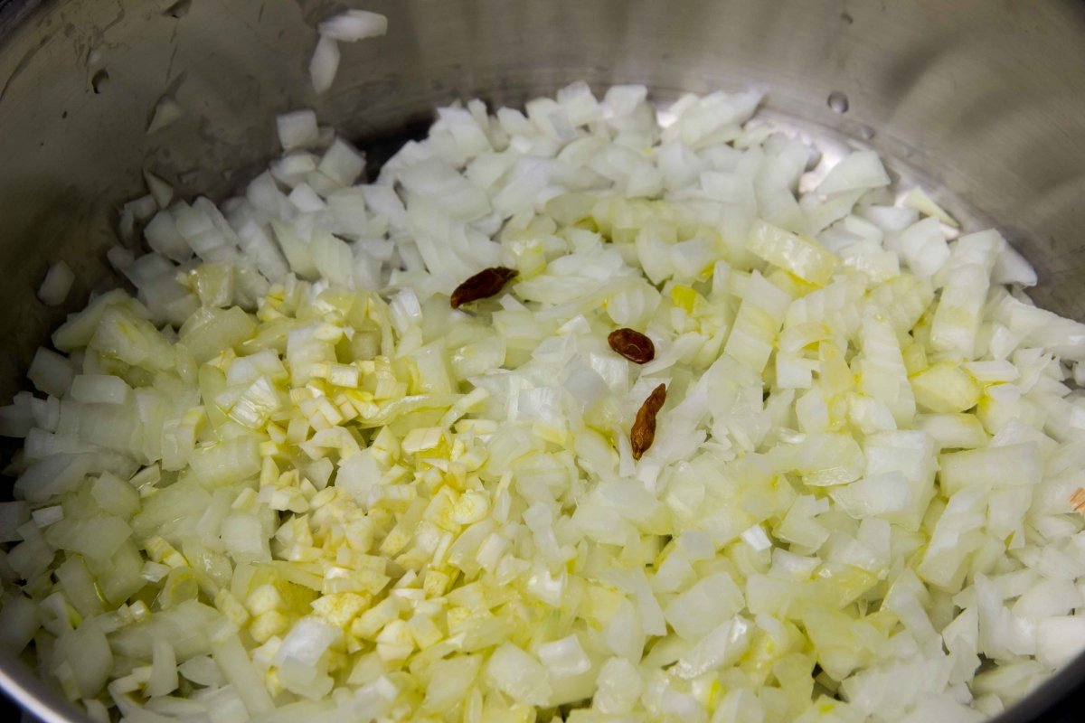 Pochar la cebolla y los ajitos con las guindillas para hacer la salsa de los caracoles montañesa