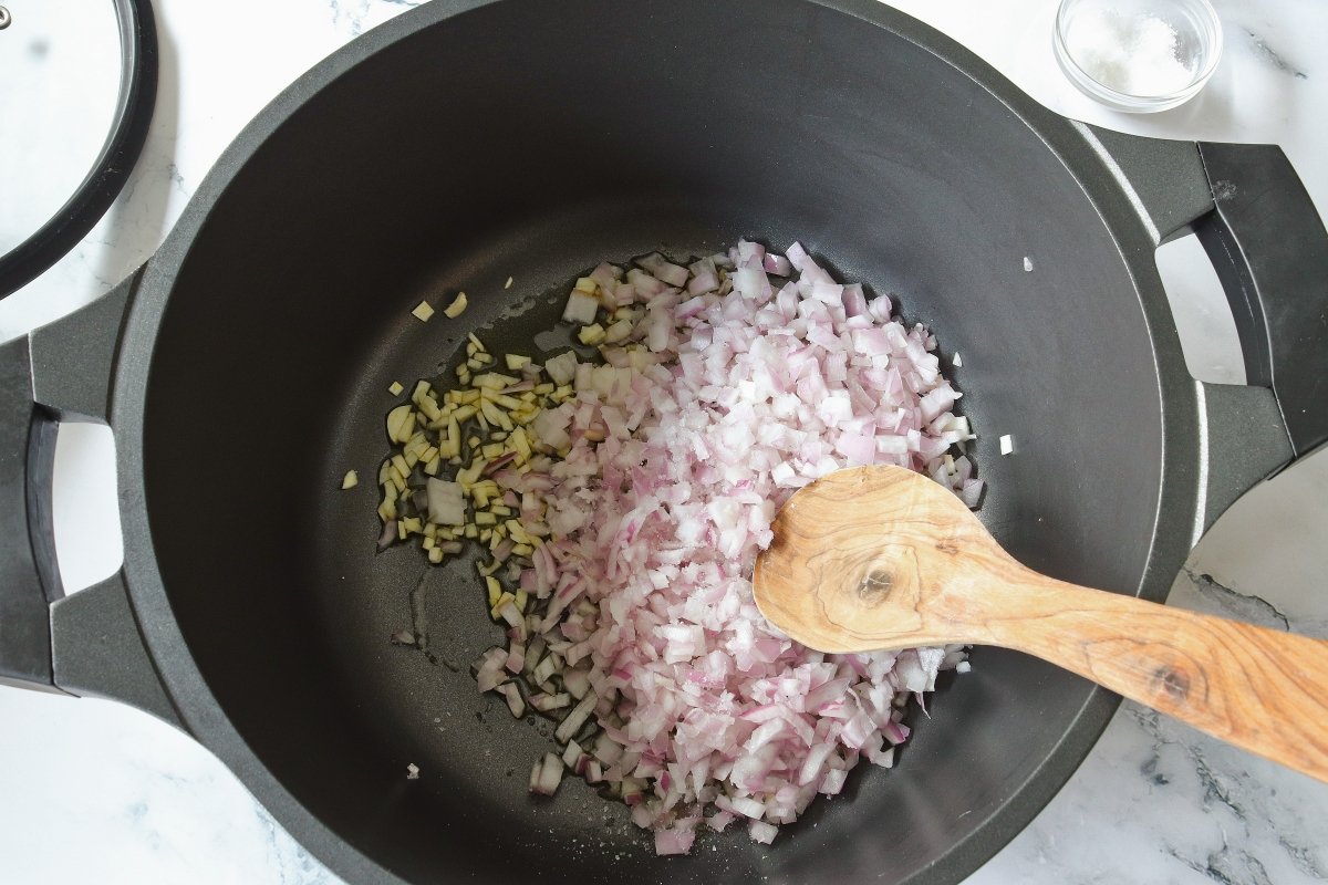 Pochar la cebolla y los ajos para el potaje de garbanzos con bacalao y espinacas