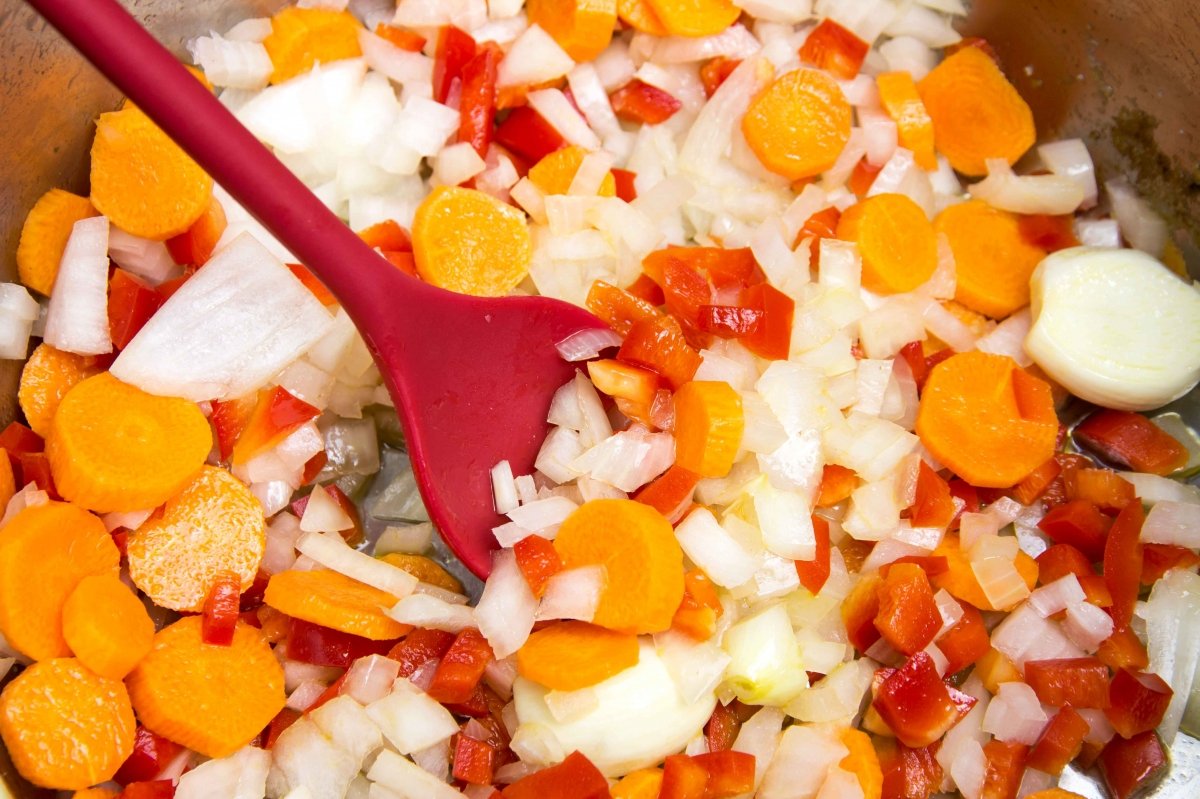 Pochar las verduras en una olla para hacer el pollo en salsa