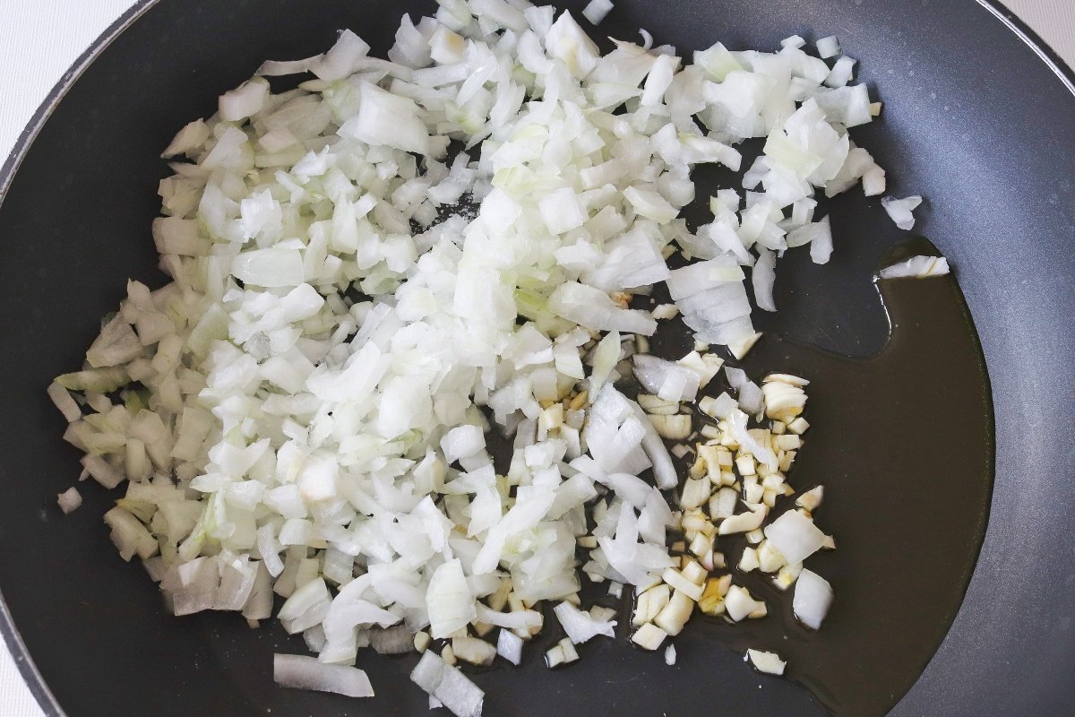 Pochar los ajos y la cebolla para los chorizos a la pomarola