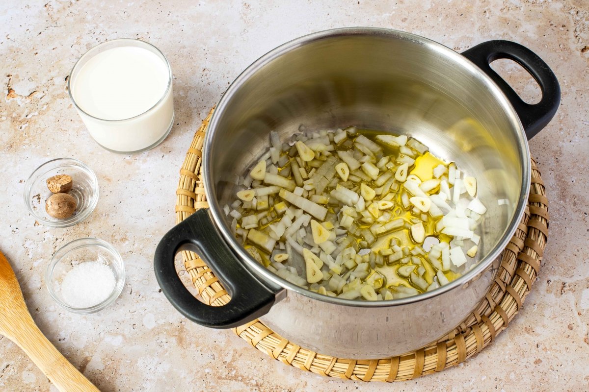 Pochar o dorar la cebolla y los ajos laminados para las espinacas a la crema gratinadas