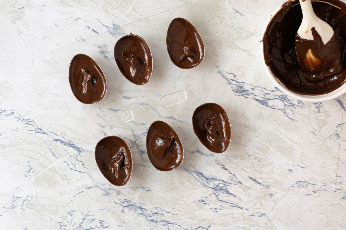 Ponemos el chocolate en los moldes de los huevos de pascua de chocolate