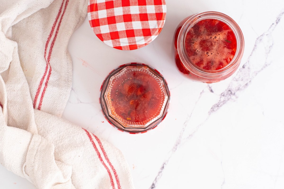 Ponemos en los tarros la mermelada de fresas y albahaca