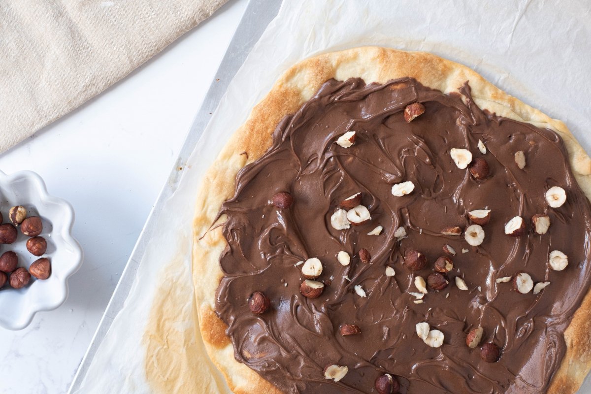 Ponemos las avellanas de la pizza de chocolate