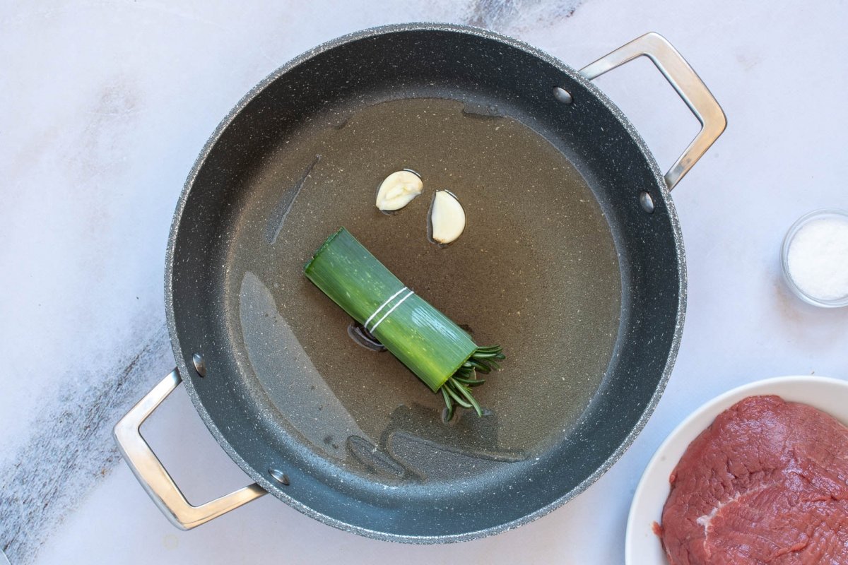 Poner aceite de oliva virgen extra en la olla junto con los ajos