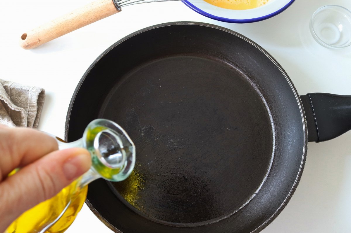 Poner aceite en sartén omelette de huevo