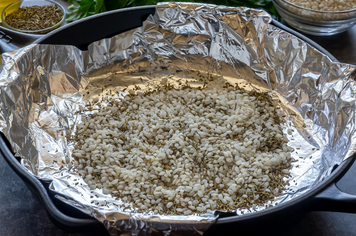 Poner el arroz con hierbas en la sartén