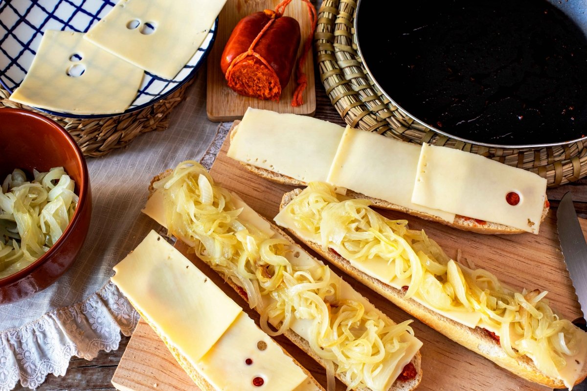 Poner el queso y la cebolla al bocadillo de Almussafes