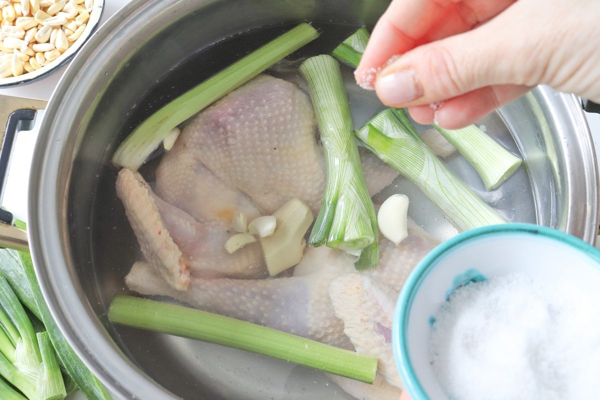 Poner en la olla la gallina con otros ingredientes para el caldo de gallina