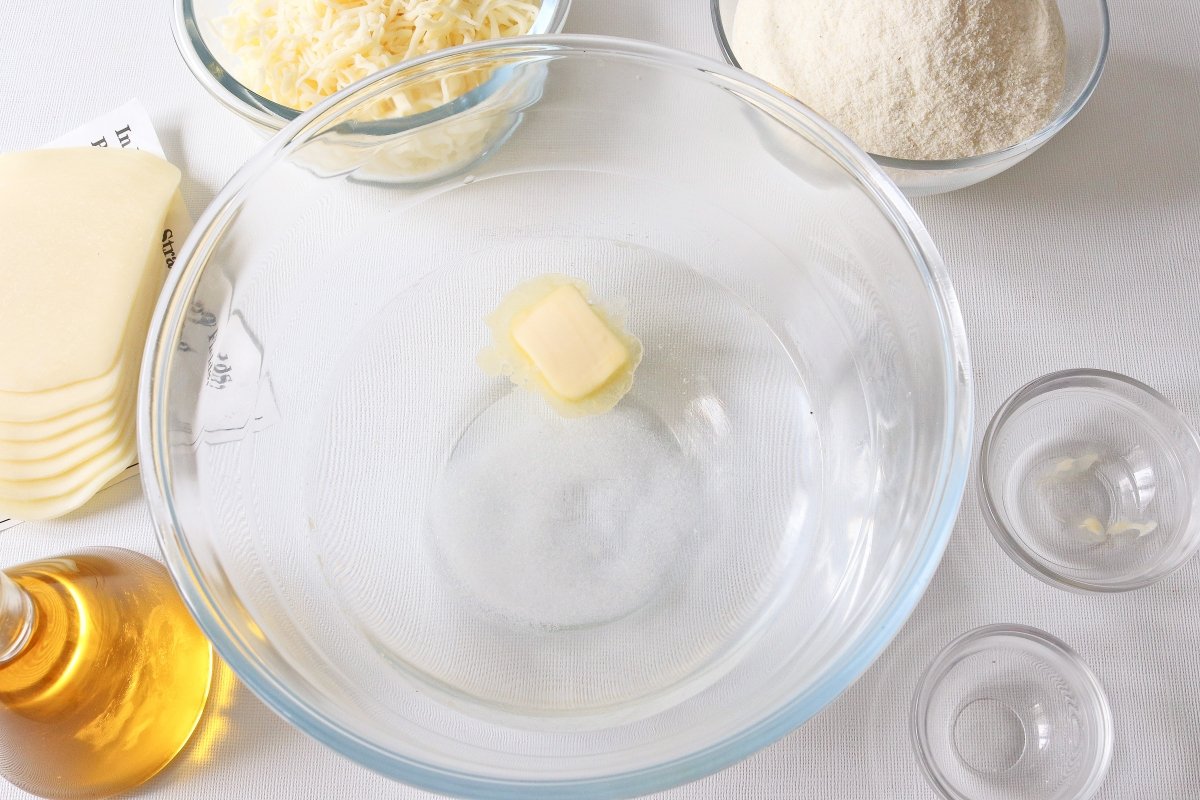 Poner en un bol agua, sal y mantequilla para las arepas colombianas con queso