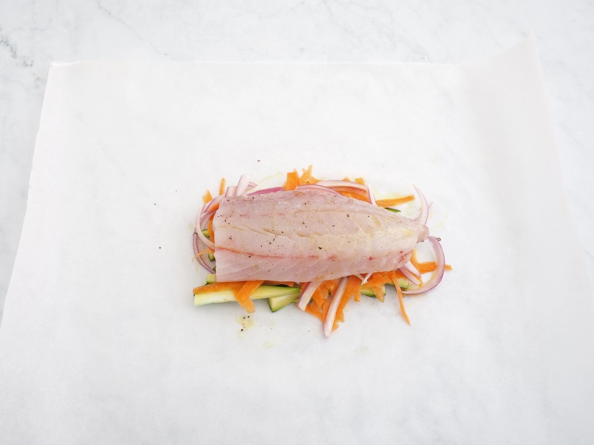 Poner la corvina sobre las verduras