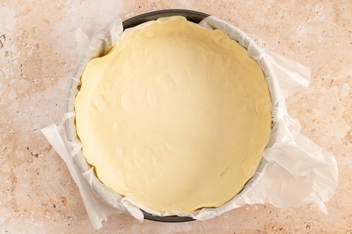 Poner la masa brisa en un molde para la torta pascualina