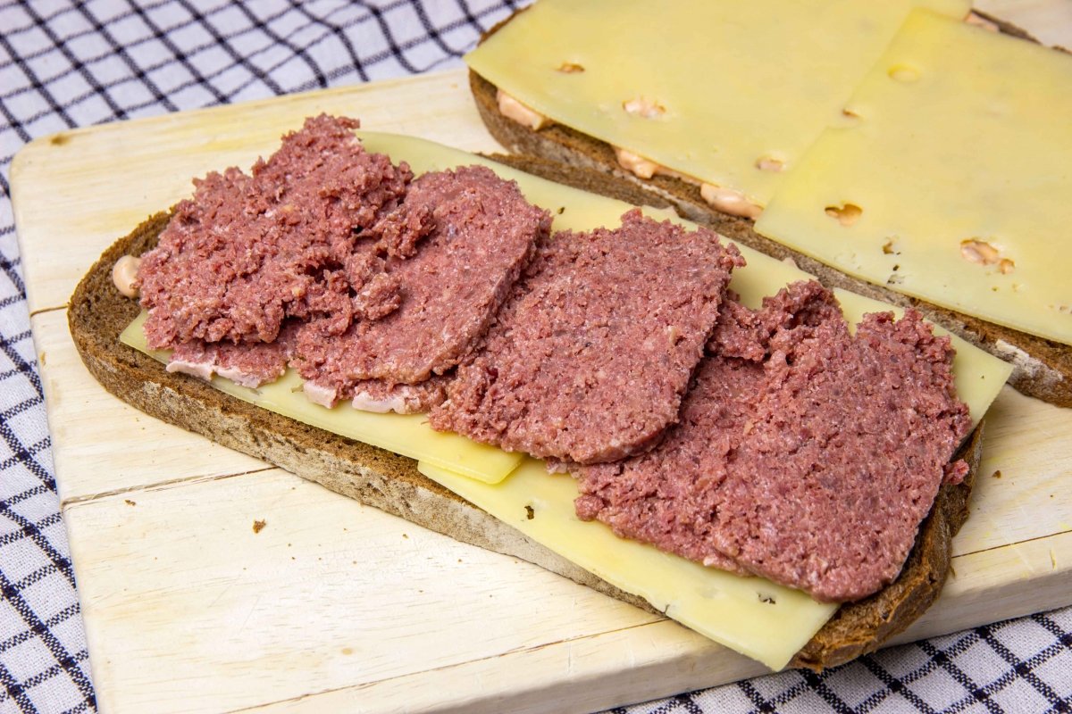 Poner las lonchas de queso y la corned beef en el sandwich reuben