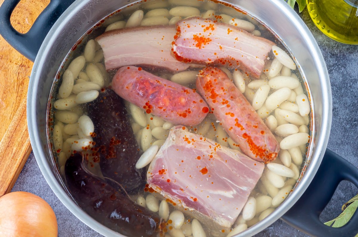 Poner los ingredientes en la olla para hacer fabada asturiana