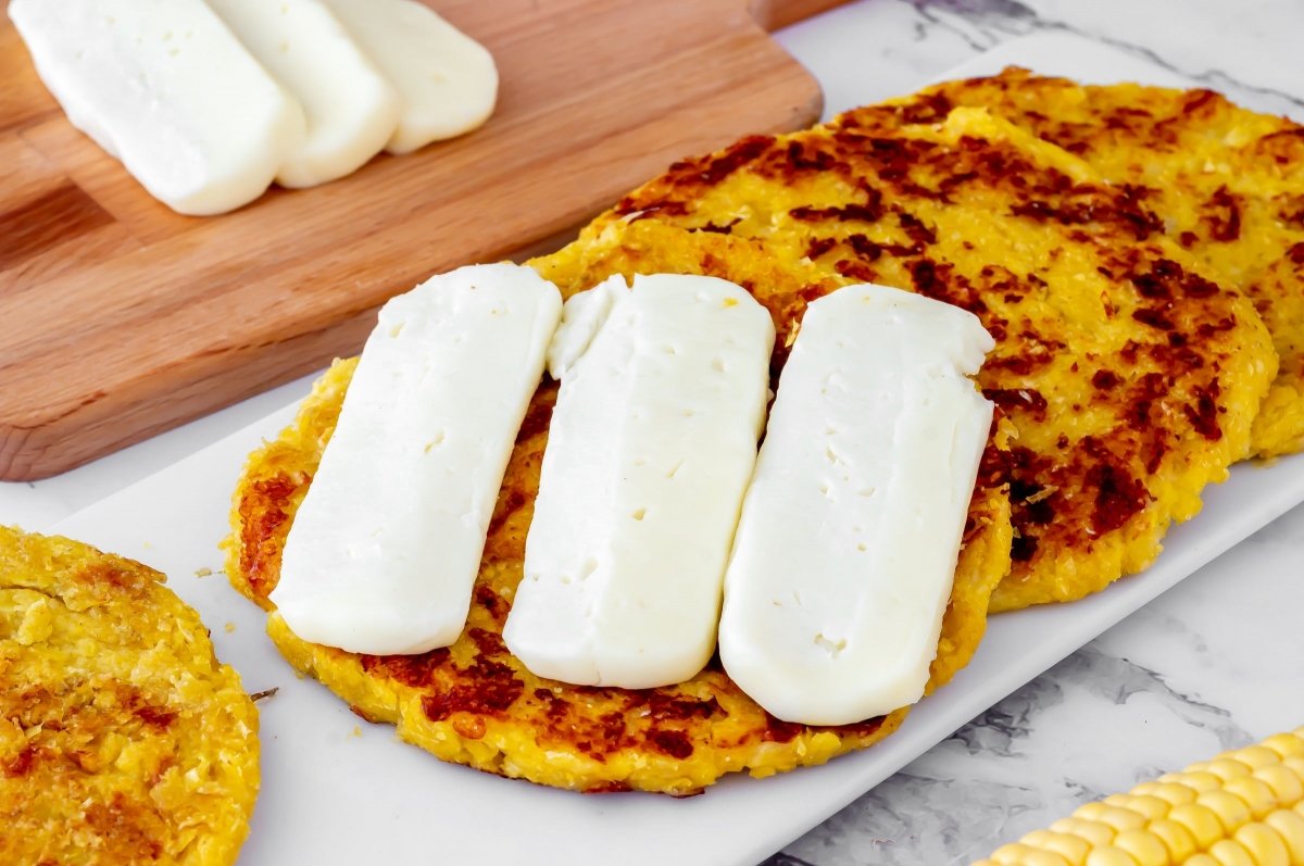 Poner queso en lonchas a la arepa de choclo