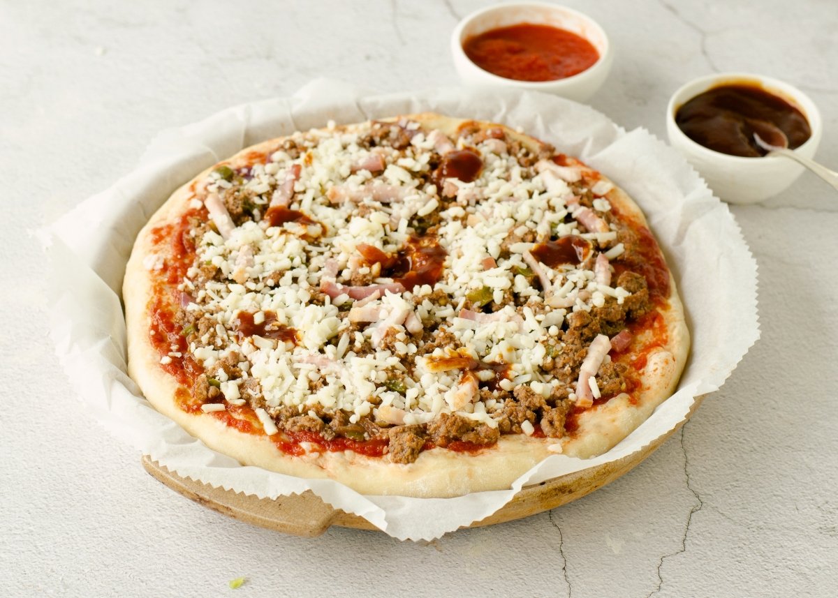Poner salsa, mozzarella y cebolla para la pizza barbacoa