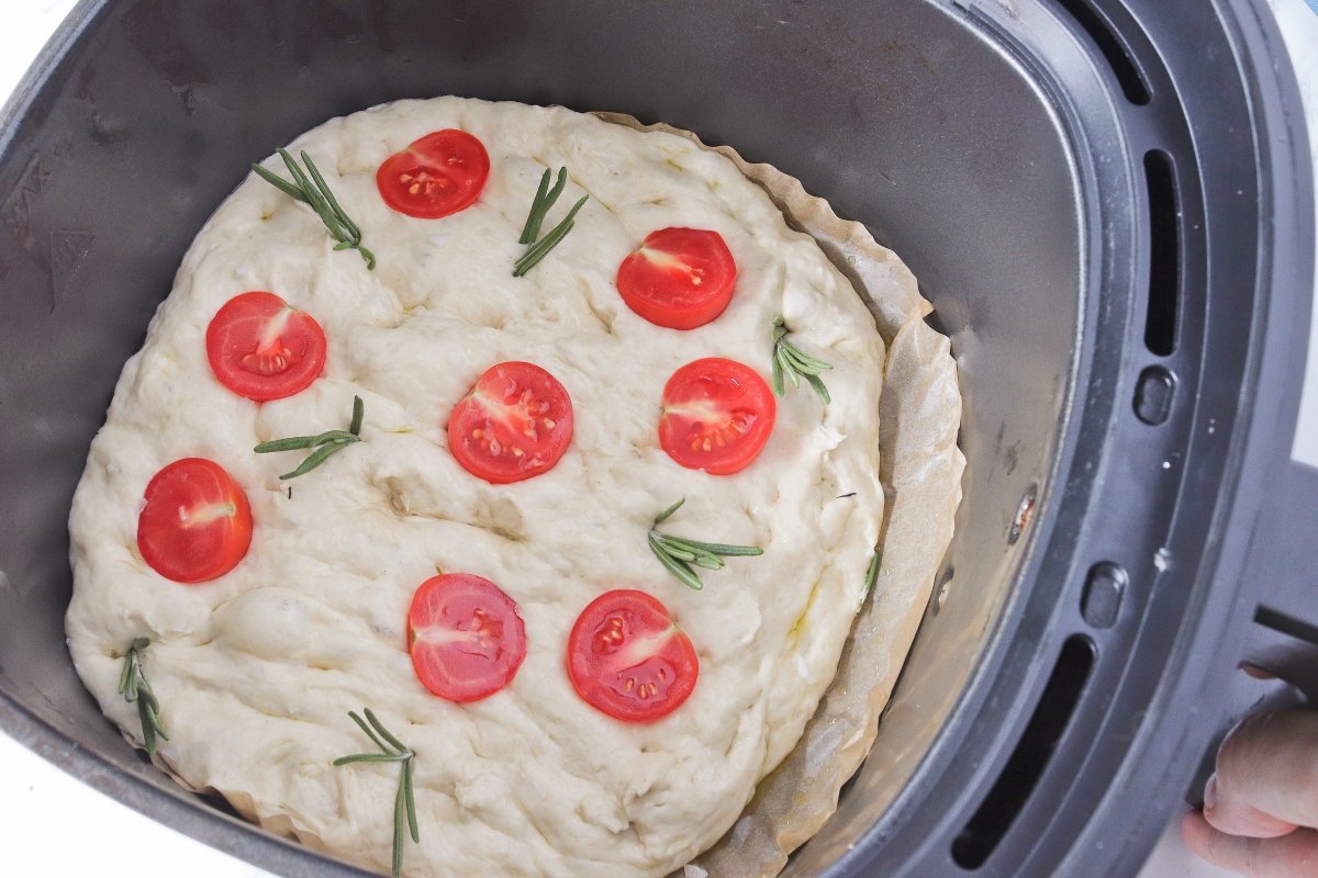 Poner tomatitos y romero a la focaccia en freidora de aire