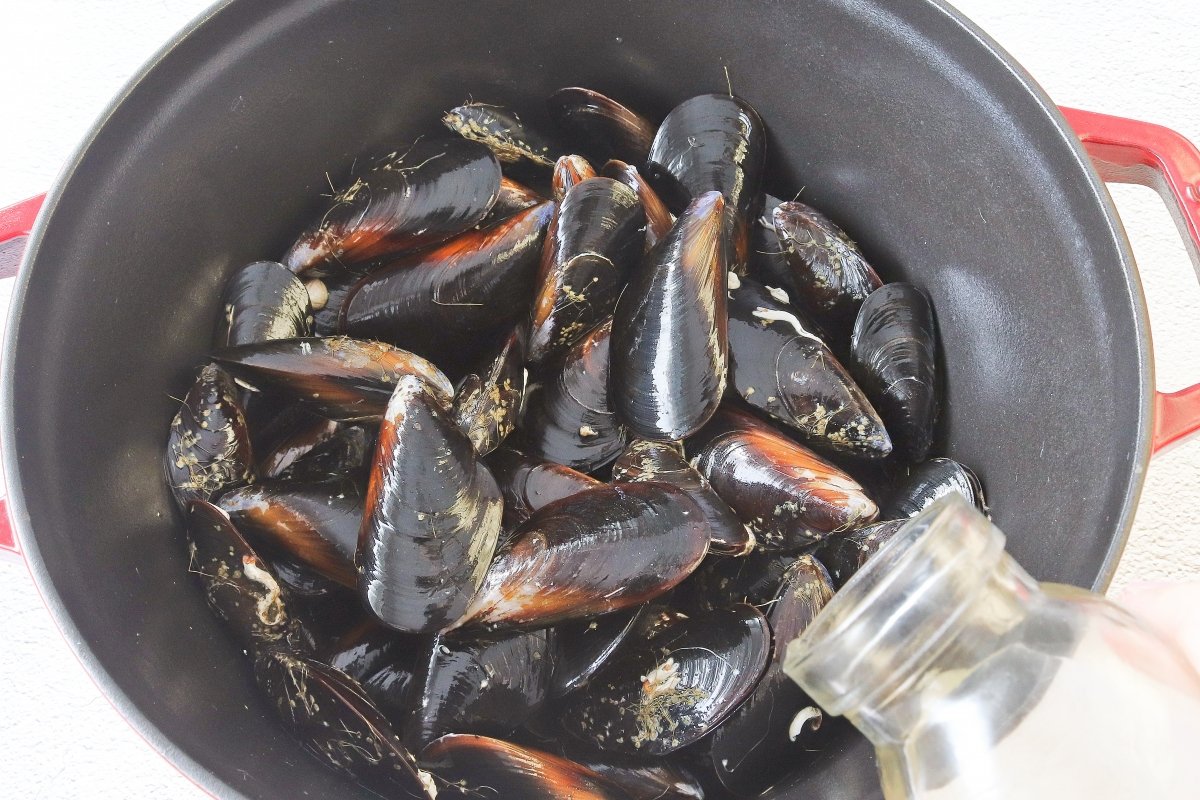 Poner vino a los mejillones para hacer la crema