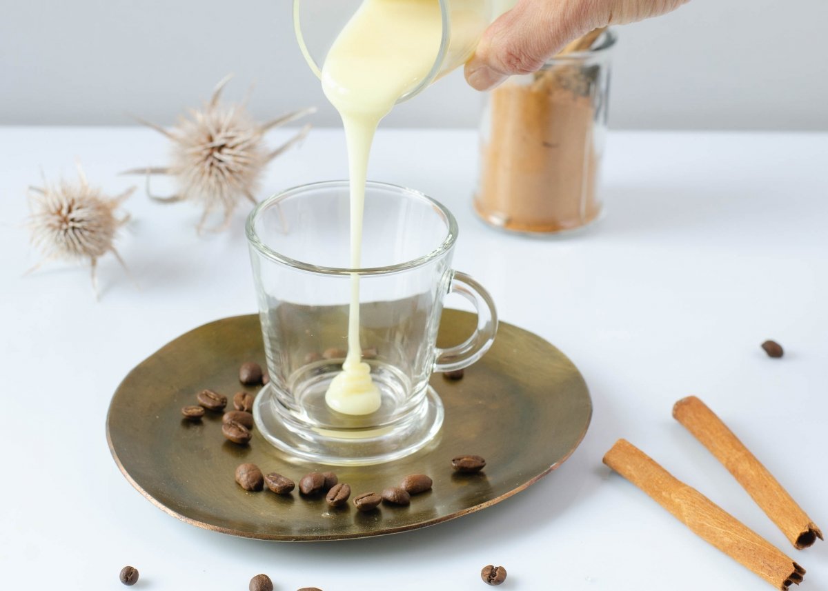 Poniendo la leche condensada del café asiatico