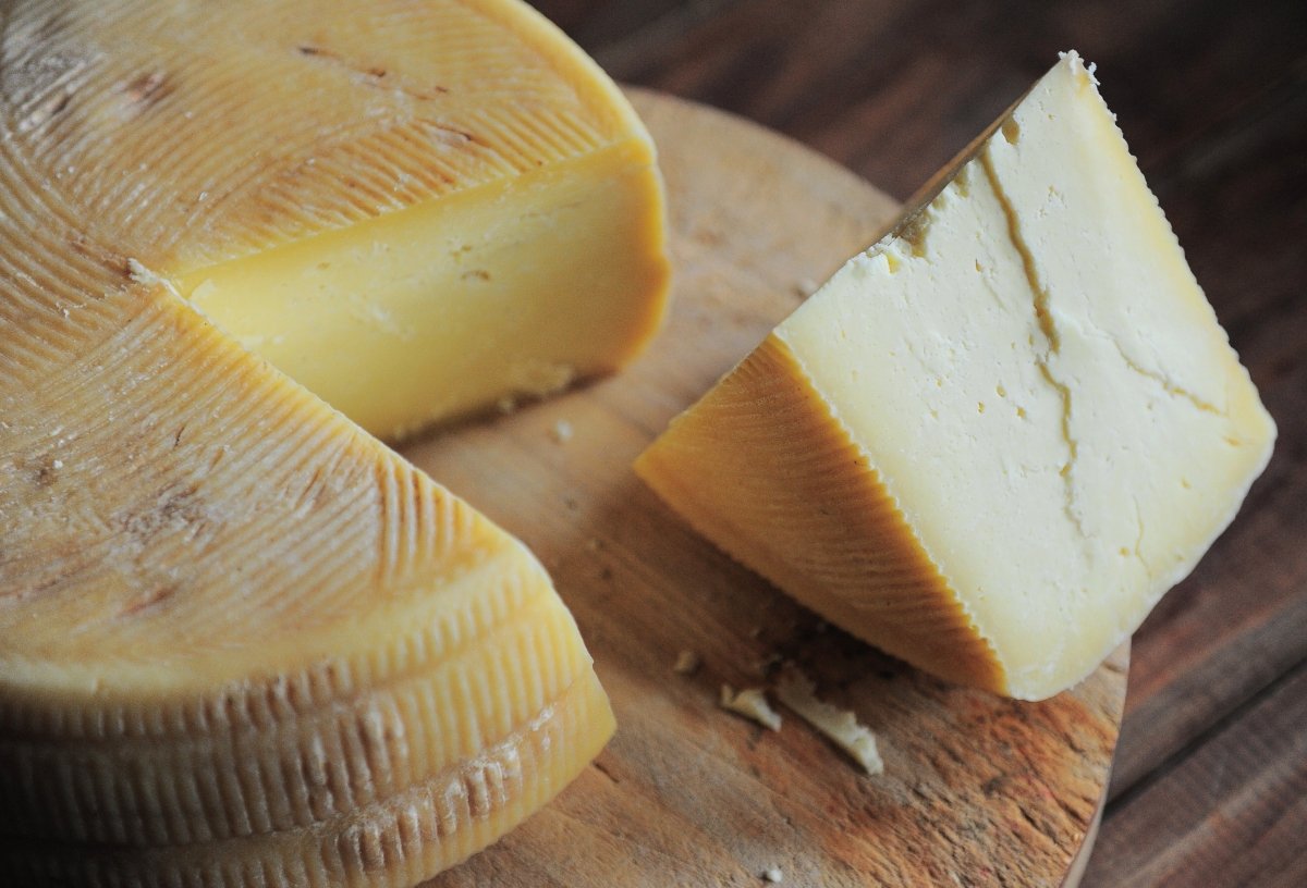 Porciones cortadas de queso curado con corteza