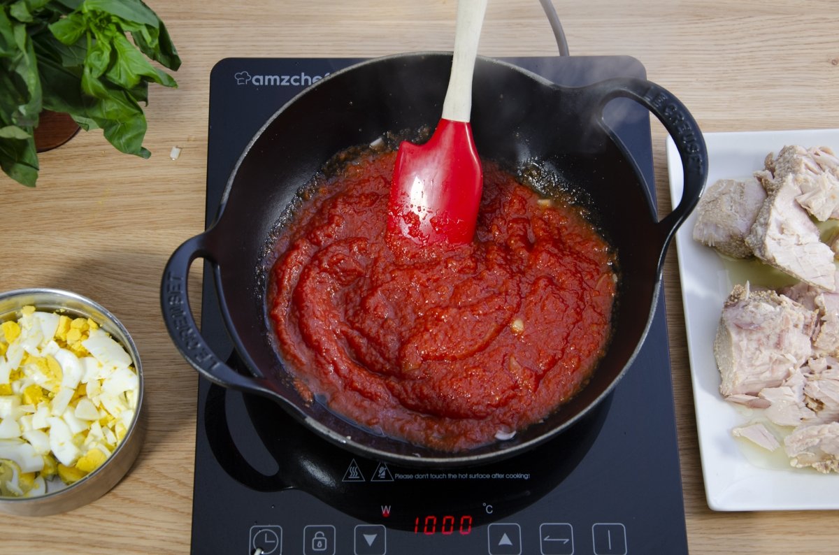 Preparando el tomate de la salsa de la lasaña