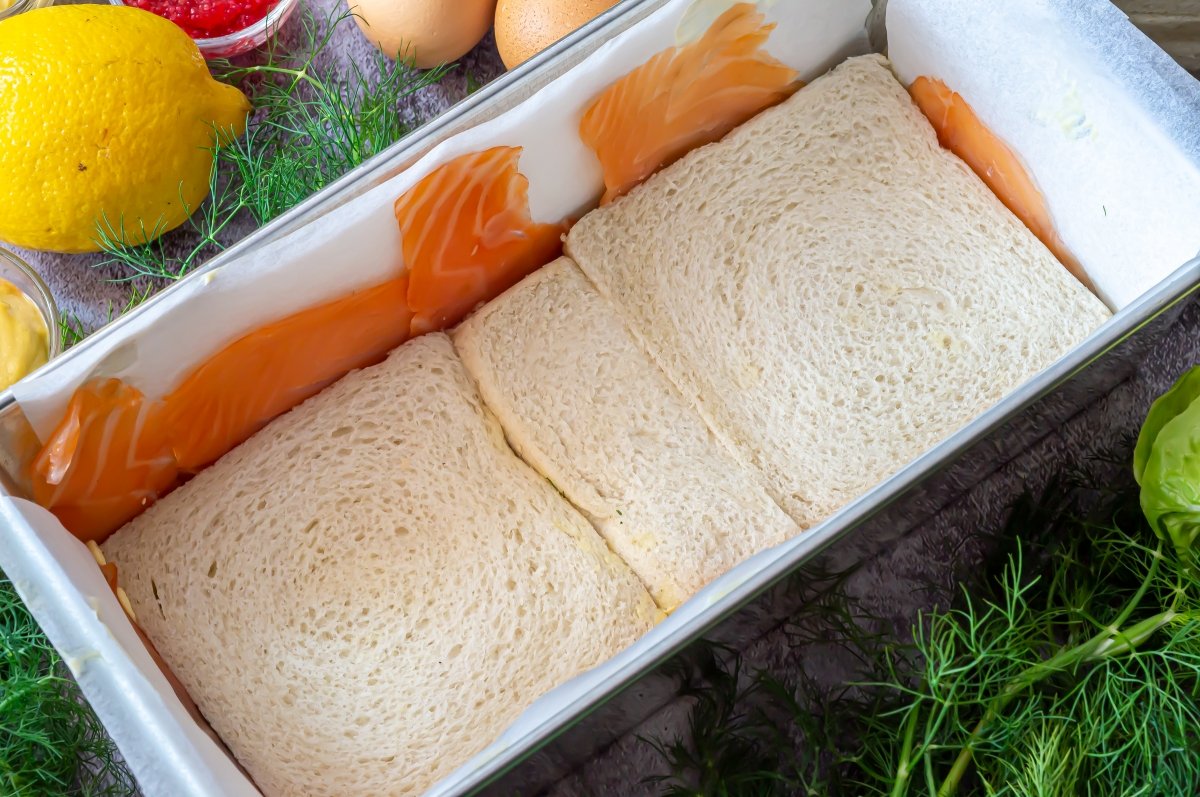 Primera capa de pan de molde del pastel de salmón