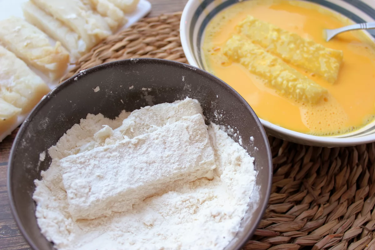Proceso de rebozado del bacalao en harina y huevo
