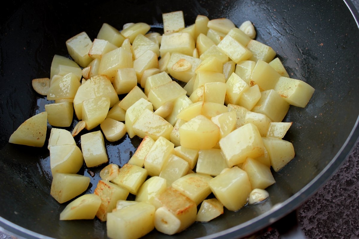 Proceso de rehogado de los ajos y las patatas