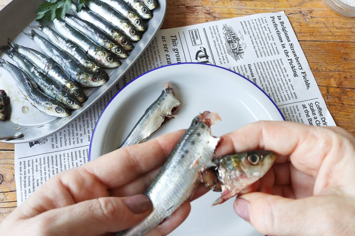 Quitar la cabeza y las tripas de las sardinas fritas