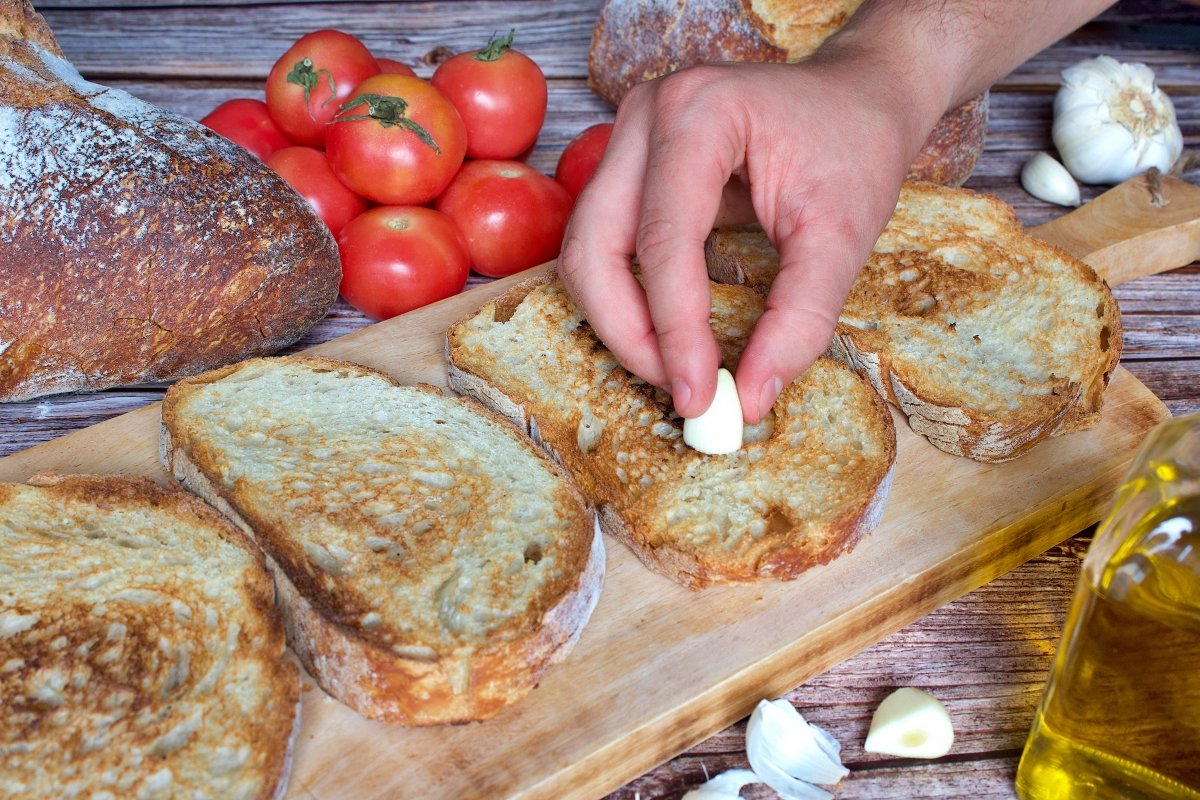 Rascando el ajo del pan con tomate (pa amb tomàquet ) en el pan
