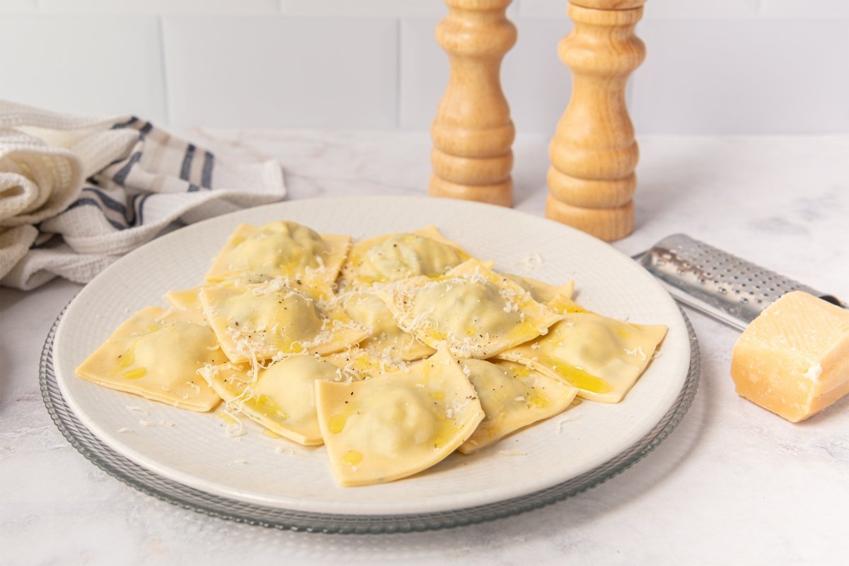 Raviolis rellenos de espinacas y requesón con queso parmesano, aceite picante y pimienta
