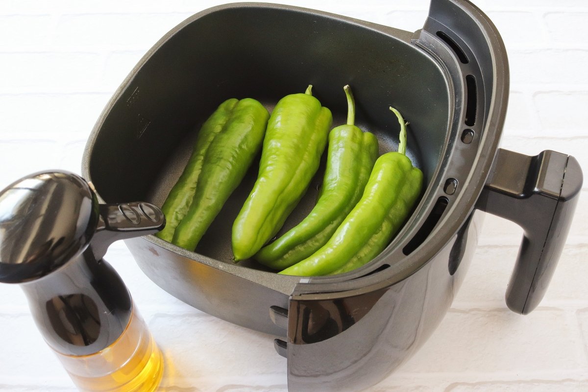 Regar los pimientos con aceite para hacerlos fritos en freidora de aire